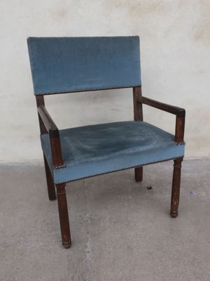 a blue chair that is sitting in front of a white wall