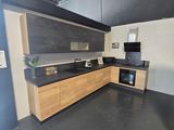 a kitchen with a black counter top and wooden cabinets