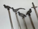 three metal spoons sitting on top of a white table