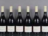 six bouteilles de vin sont alignées sur une table