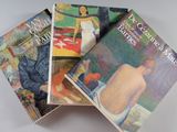 trois livres sont empilés sur une table
