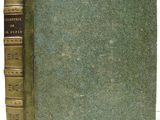 an old book sitting on top of a table next to a white table