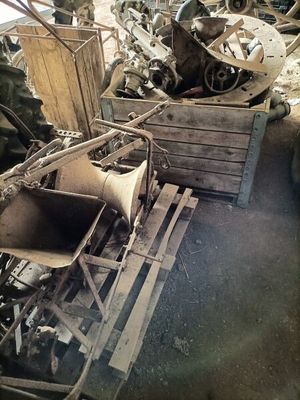 un tas de ferraille dans une casse, avec un homme à l'arrière-plan