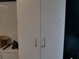des placards dans une pièce où se trouvent une poubelle et une poubelle