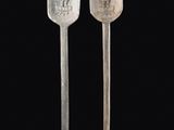deux cuillères en argent ornées de gravures sur fond noir