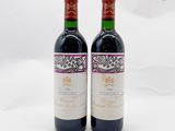 deux bouteilles de vin posées l'une à côté de l'autre sur une surface blanche