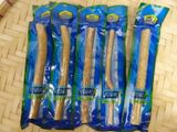 four bags of toothbrushes sitting on top of a bamboo mat