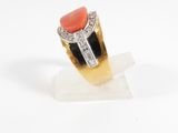 a close up of a ring with a coral stone and diamonds