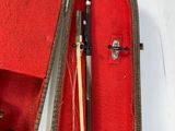 a violin in a case with a wooden stick in it
