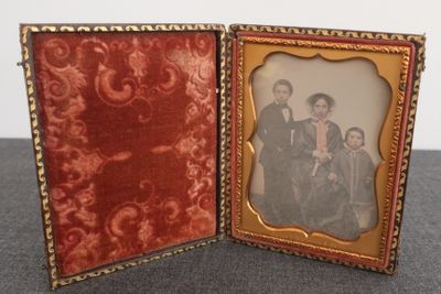 une vieille photo de famille dans un cadre posé sur une table