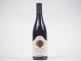 une bouteille de vin rouge posée sur une table blanche