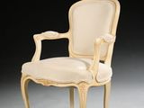 a white chair with a beige upholstered back and arms