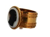 an image of a gold ring with a black and white stone in the center