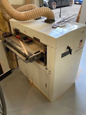 une machine qui se trouve dans un garage, avec un tuyau posé dessus