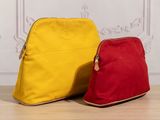 yellow and red purses sitting on a wooden floor in front of a white wall
