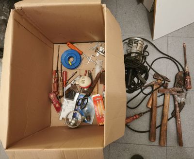 a cardboard box filled with tools on the floor