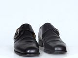 paire de chaussures en cuir noir avec boucles sur fond blanc