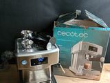 une cafetière en argent et une boîte posées sur une table en bois