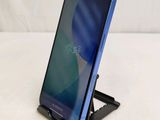 a close up of a cell phone on a stand on a white surface