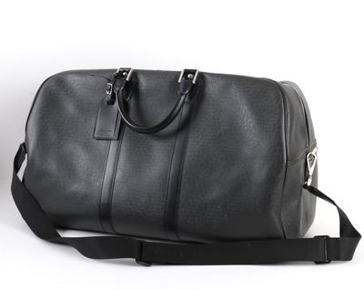 un sac de voyage noir posé sur une surface blanche