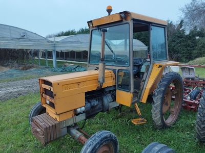 un tracteur jaune qui est garé dans l'herbe