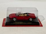 a red model car in a clear case on a table