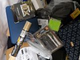 a pile of items sitting on a bed next to a laptop