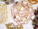 many different types of beads and chains on the table