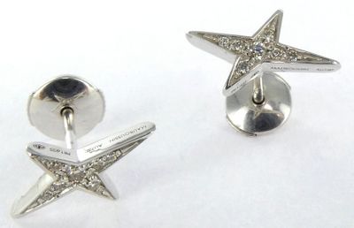 paire de boucles d'oreilles en forme d'étoiles de mer en argent, ornées de diamants sur fond blanc