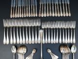 an assortment of silverware including forks and spoons on a table