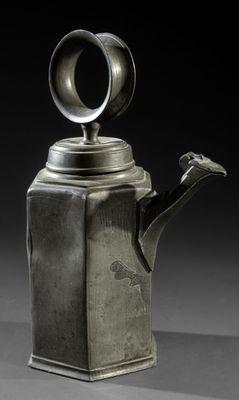 une théière ancienne en argent surmontée d'un oiseau
