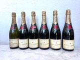 six bouteilles de champagne alignées sur une table