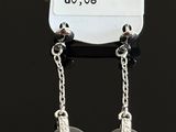 pair of black heart shaped earrings hanging from a tag on a black surface