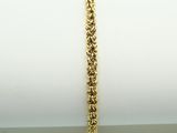 a close up of a gold bracelet on a white napkin