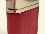 a close up of a red glass container with a gold lid