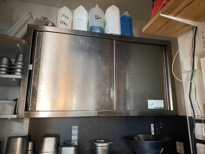 a stainless steel cabinet in the middle of a kitchen