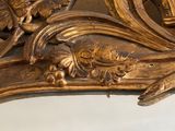 a mirror that has a gold frame with flowers on it