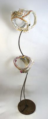 a metal sculpture of a bird on a stand