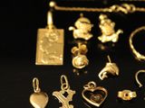 a collection of gold jewellery on a black background