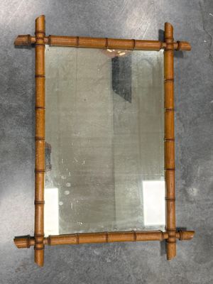 un miroir accroché au mur, avec un cadre en bambou
