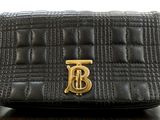 an image of a black purse with a gold b on it