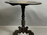 une table noire avec un plateau en métal et un piètement en bois