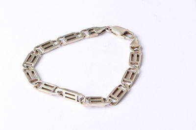 a close up of a silver chain bracelet on a white surface