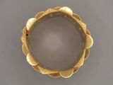gros plan d'une bague en or sur une surface grise