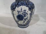 un vase bleu et blanc posé sur une surface blanche