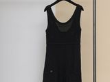 une robe noire suspendue à un portant dans une pièce