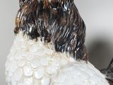 a white and black rooster figurine with a red hat on it ' s head