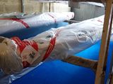 deux mannequins emballés dans du plastique dans une pièce