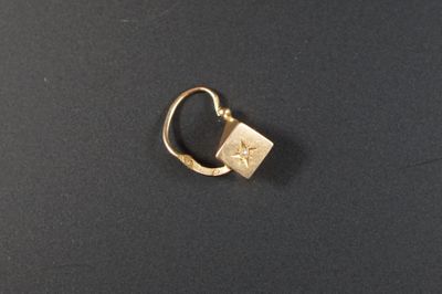 gros plan d'une bague en or sur une surface noire