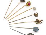 a group of various metal and glass brooches and pins
